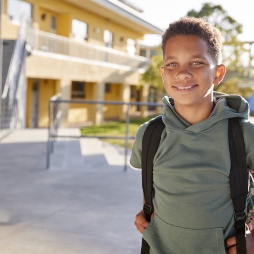 portrait-of-smiling-elementary-school-boy-with-his-backpack